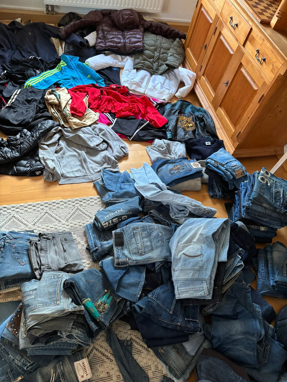 Berge an Markenkleidung und Jeans beim Sortieren für den Weiterverkauf